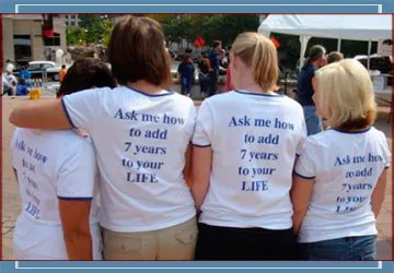 Four women wearing shirts standing backwards
